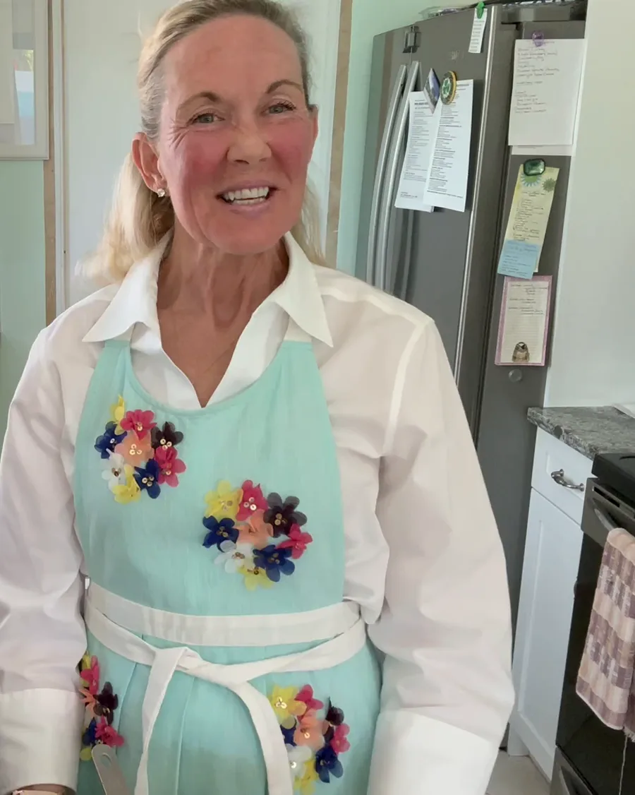 Tracey O’Hara smiling in her kitchen, wearing a flowered apron